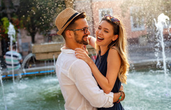 laughing couple in love embracing over the fountain