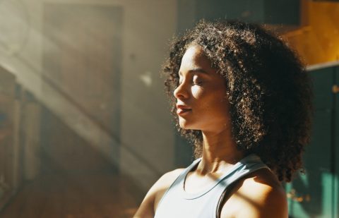 Calm woman, relax and sunlight with meditation at home for zen, awareness or mindfulness. Female person, yogi or balance with inner peace for stress relief, breathing exercise or wellness at house